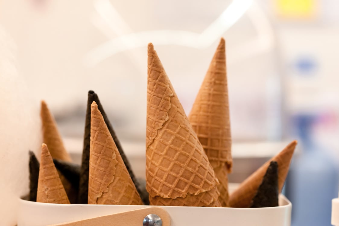 Container with delicious waffle cones in restaurant