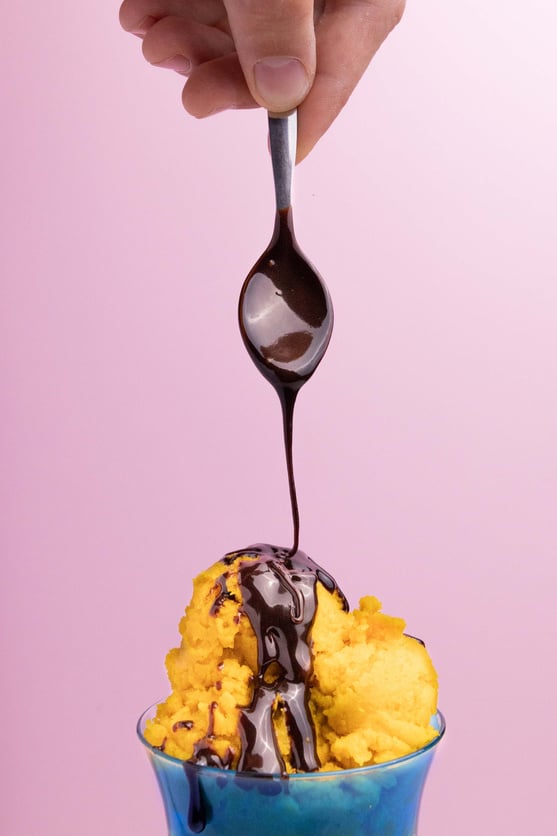 Spoon with Pouring Chocolate Syrup on Ice cream 