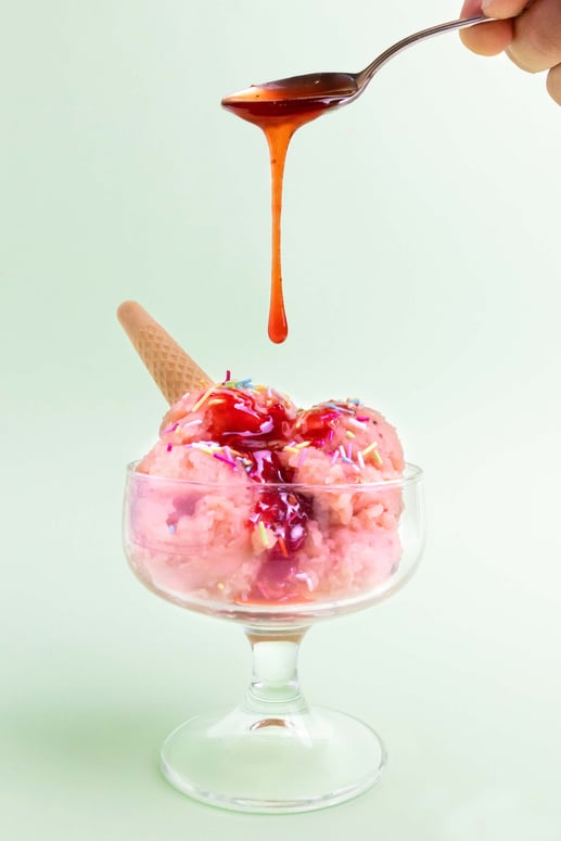 Hand Dripping Syrup on Bowl of Ice Cream