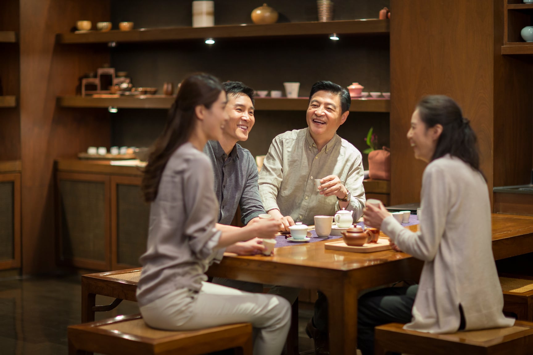 Cheerful Chinese Friends Drinking Tea Together in Tea Shop